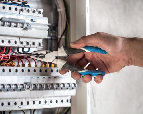 electrical-technician-working-switchboard-with-fuses_169016-5512