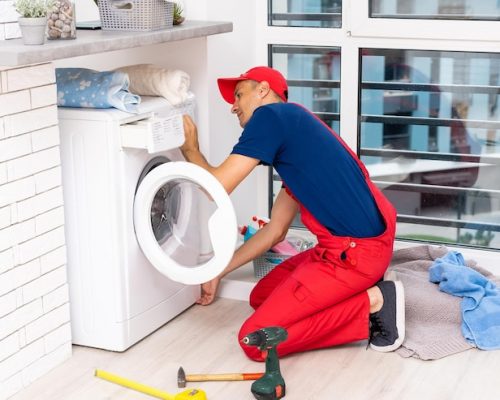 male-adult-repairman-with-tool-clipboard-checking-washing-machine-bathroom_493343-24563